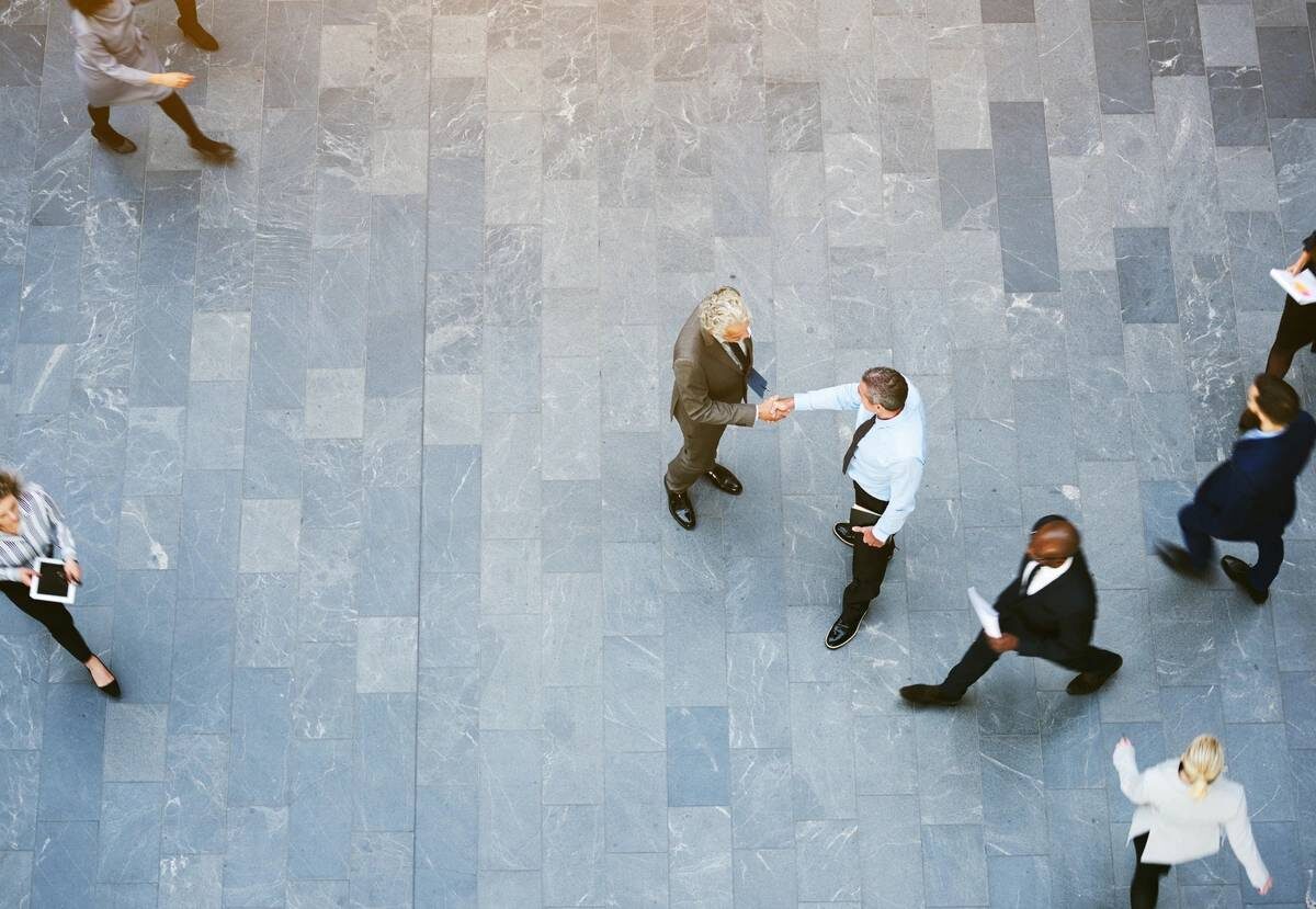 Aerial view of a busy office space with people walking and conversing in business consulting setting